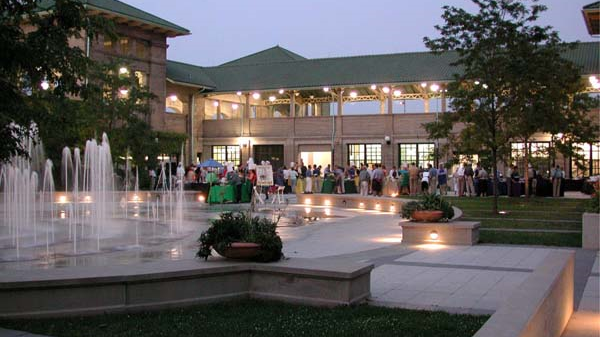 Evening gathering at a brick building with a courtyard fountain.